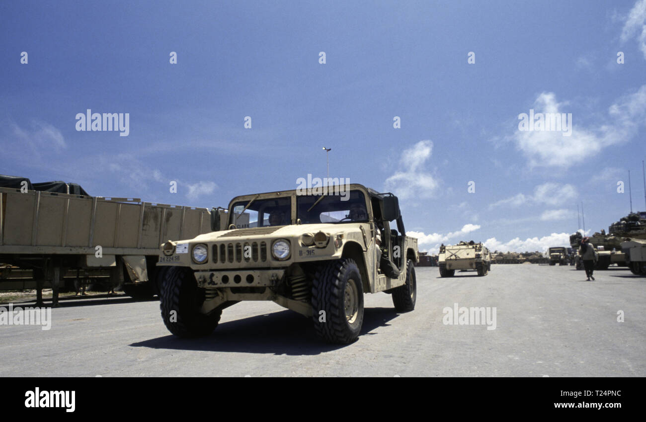 30. Oktober 1993 einen US-Army Humvee durch M 113 APCs gefolgt, die nur vom Meer aus in den neuen Hafen in Mogadischu, Somalia angekommen sind. Auf der rechten Seite M1A1 Abrams Panzer, auch früh am Morgen entladen. Stockfoto