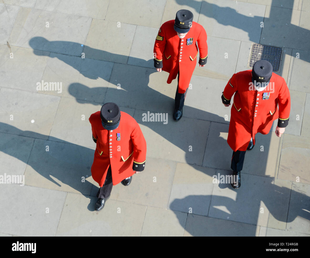 Chelsea Rentner, von der Royal Hospital Chelsea, ihre traditionellen scarlet Mäntel tragen, auf einem Sommer; s Tag nahe der Tower von London, Großbritannien Stockfoto