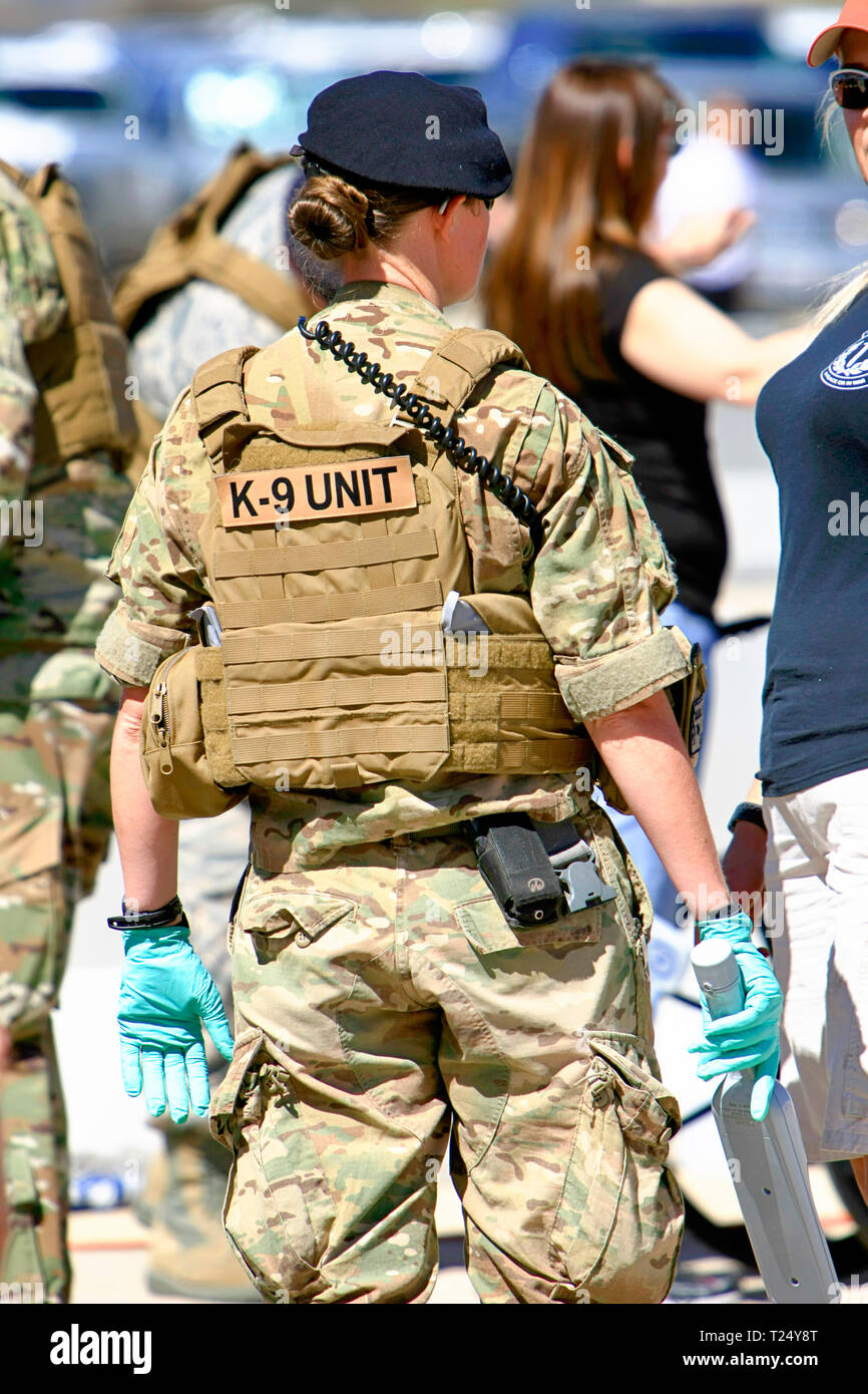 Weibliche Flieger der USAF K-9 unit Gummihandschuhe zu tragen und mit einem Metalldetektor Zauberstab auf die DAVIS-MONTHAN AFB in Tucson AZ Stockfoto