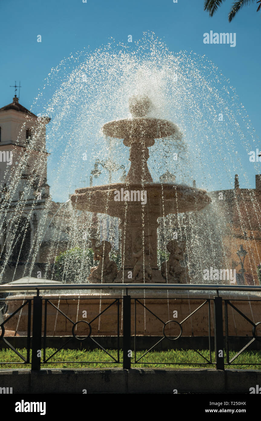Brunnen mit Wasser spritzen auf einem Platz vor der Kirche und Gebäude in  Merida. Die Stadt bewahrt viele Gebäude des antiken Roms in Spanien  Stockfotografie - Alamy