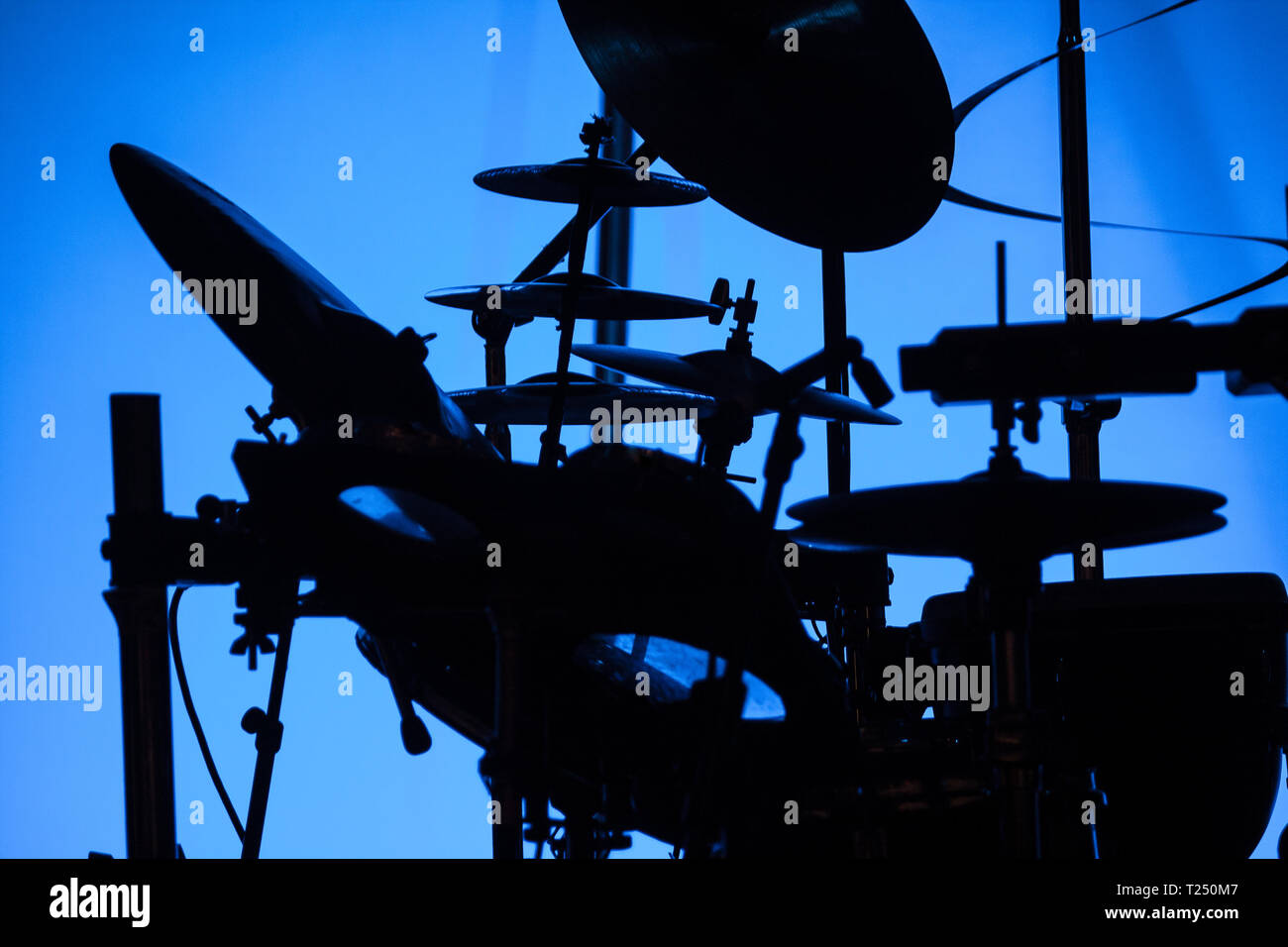 Silhouette einer Trommel vor der blauen Bühne Licht gesetzt Stockfoto