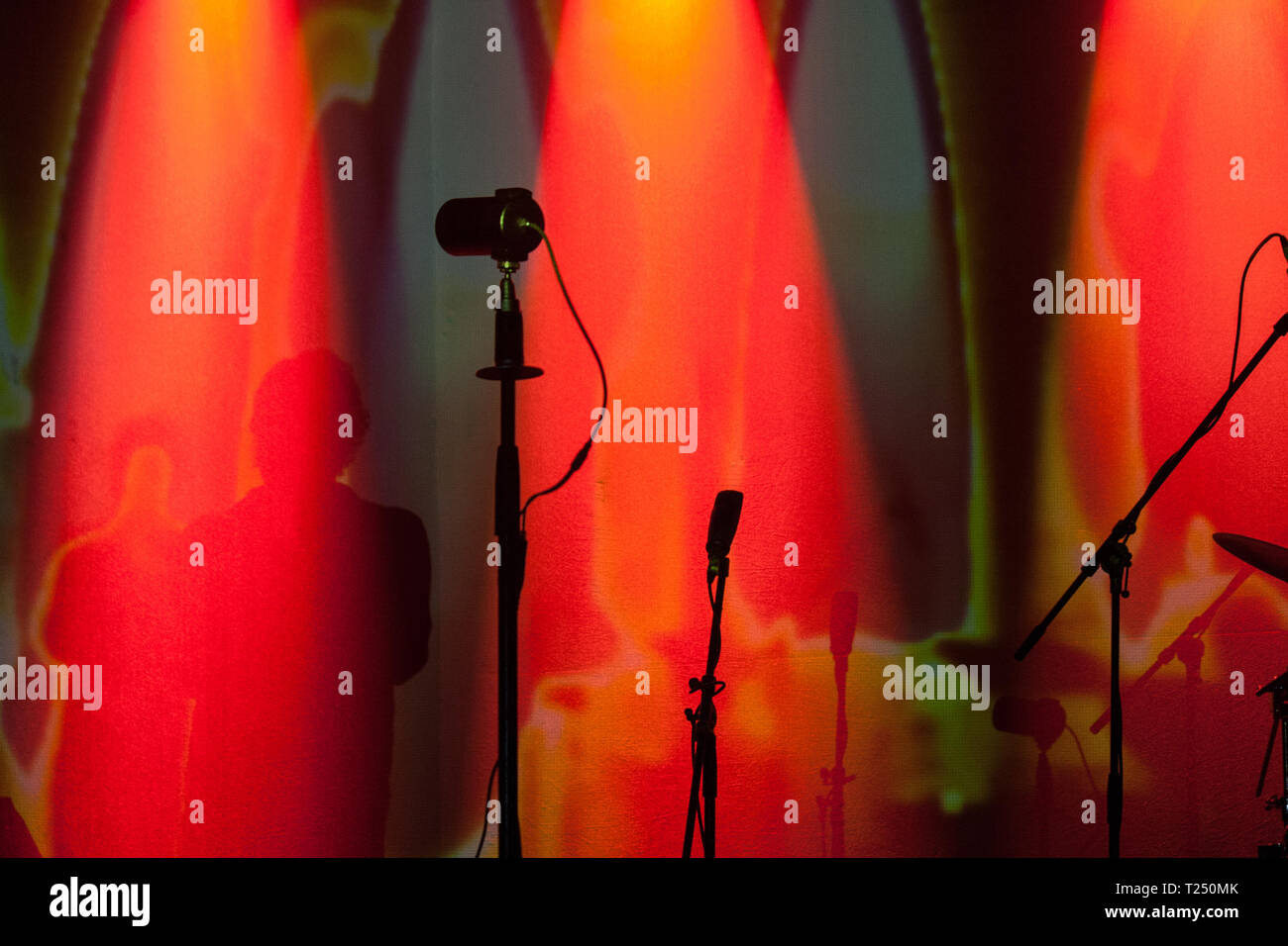 Silhouette der Mikrofone auf der Bühne in rotes Licht Stockfoto