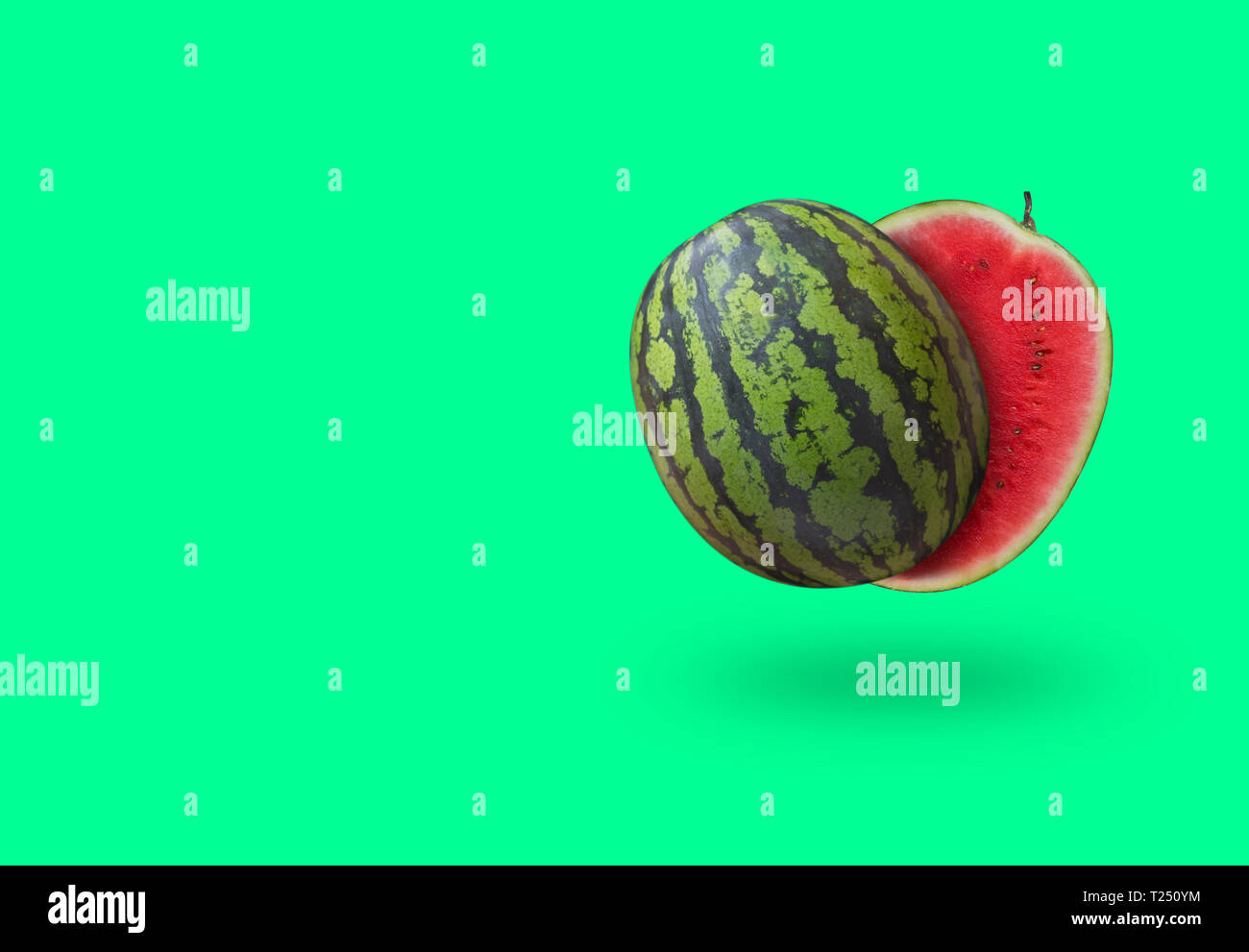 Geschnittenen Wassermelone auf Grün pastell Hintergrund mit Schatten und kopieren Raum isoliert. Horizontale Ausrichtung Stockfoto