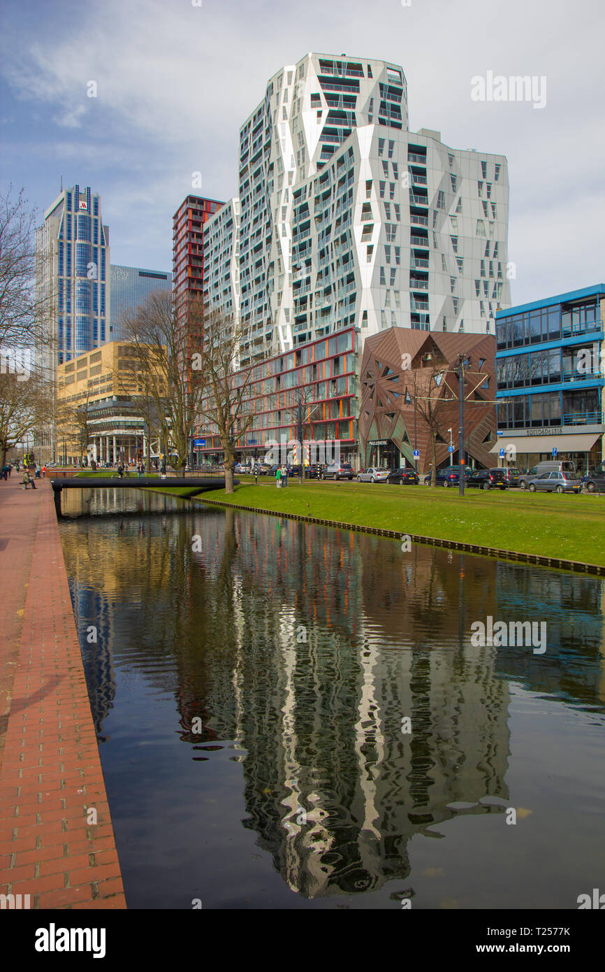 Rotterdam, Niederlande - 7 April 2018: Moderne Architektur des Stadtzentrums von Rotterdam mit Reflexionen über den Kanal, die Brücke und die grüne Fläche in foregrou Stockfoto