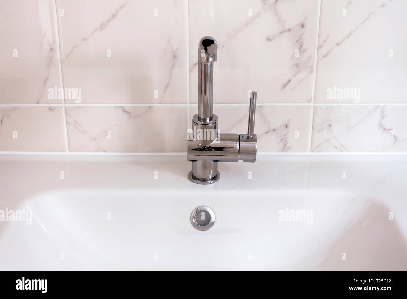 Neuen Hahn mit weißen Waschbecken im Badezimmer. Stockfoto