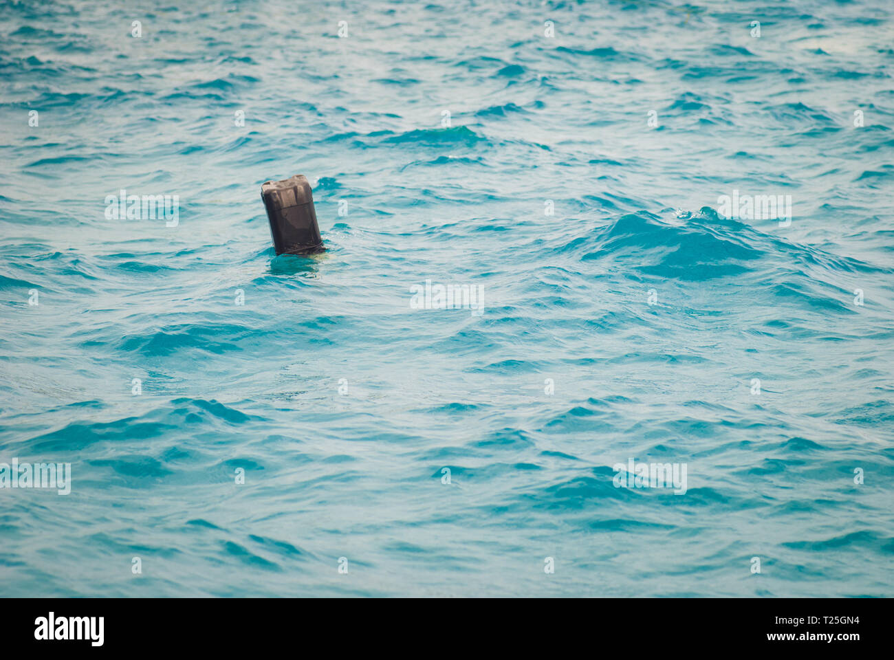 Schwarze Plastikbehältnis schwimmt im Meer. Hausmüll, Konzept der Mangel an Respekt für die Umwelt Stockfoto