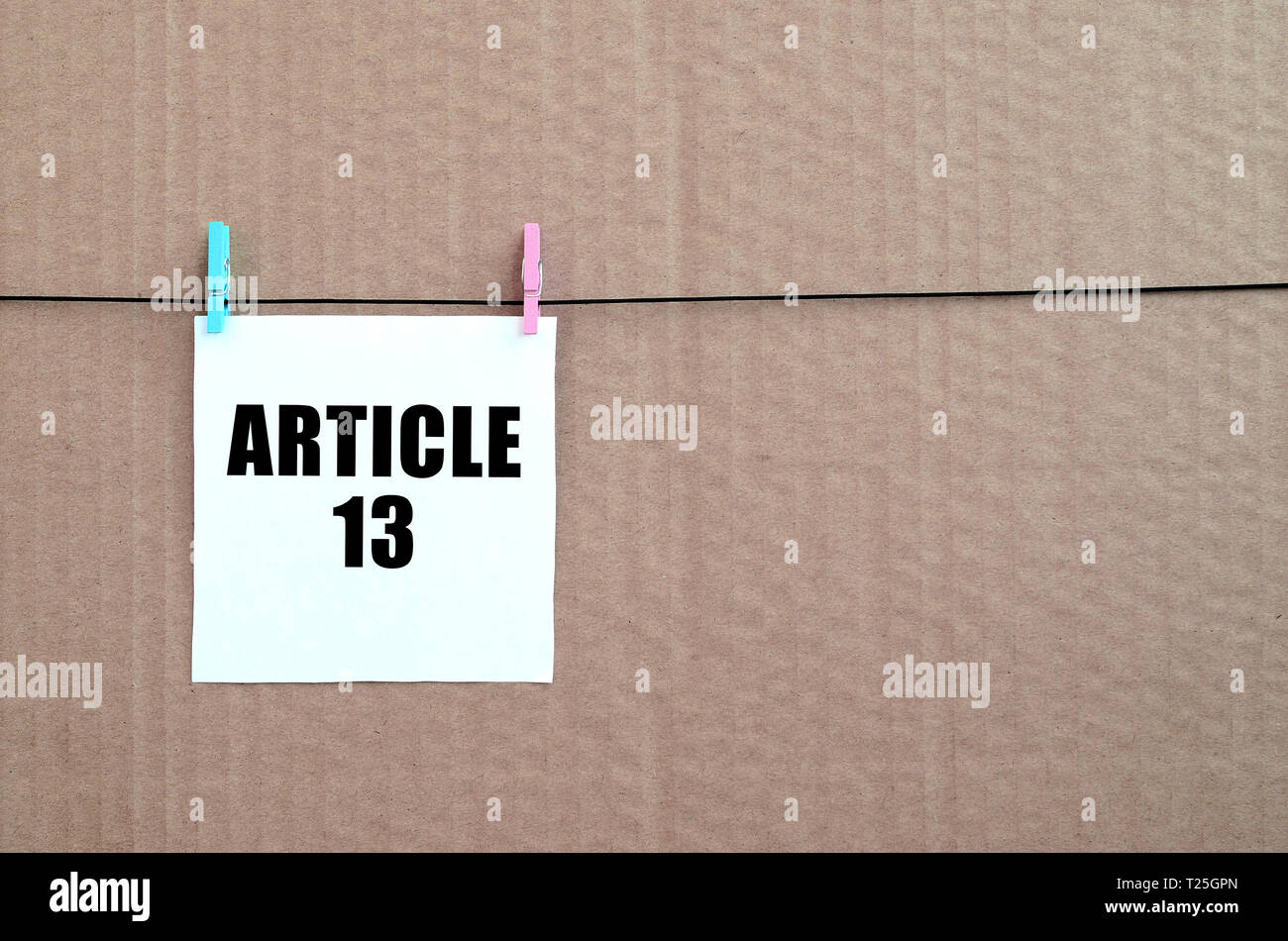 Artikel 13 Die Aufschrift am weißen Karte am Seil auf einem braunen Karton Hintergrund. Die europäische Richtlinie zum Urheberrecht einschließlich Artikel 13 wird durch das Europea genehmigt Stockfoto