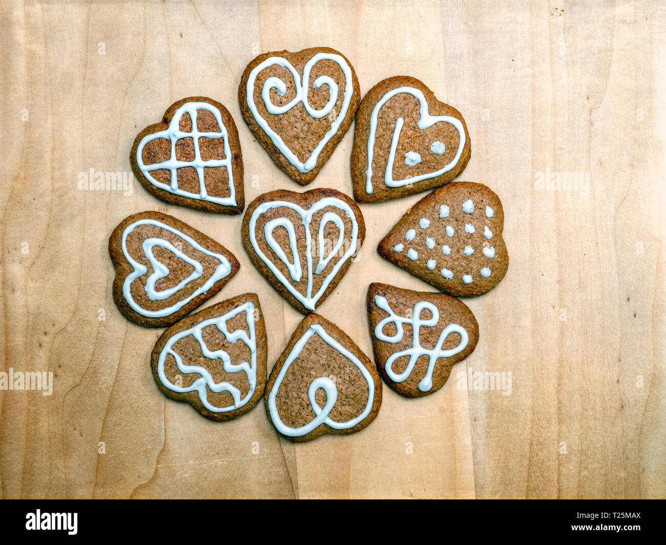 Heart-shaped Weihnachten Lebkuchen cookies mit weißer Zuckerglasur auf Holz- rustikalen Board geschossen von oben angeordnet Stockfoto