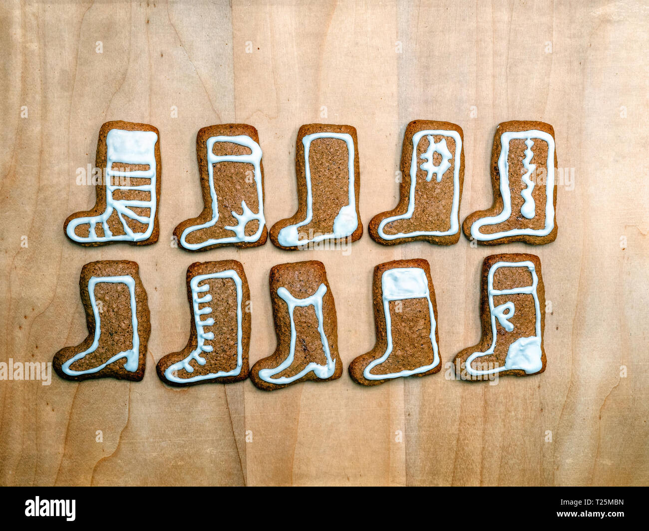 Schuh-förmige Weihnachten Lebkuchen cookies mit weißer Zuckerglasur auf Holz- rustikalen Board geschossen von oben angeordnet Stockfoto