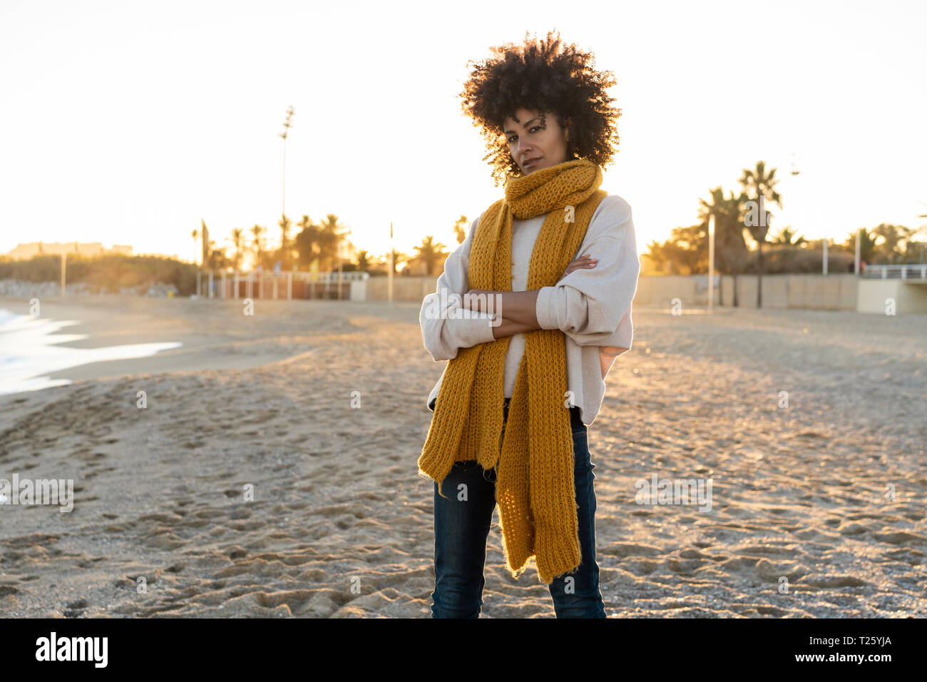 Coole Frau am Strand mit gekreuzten Armen Stockfoto