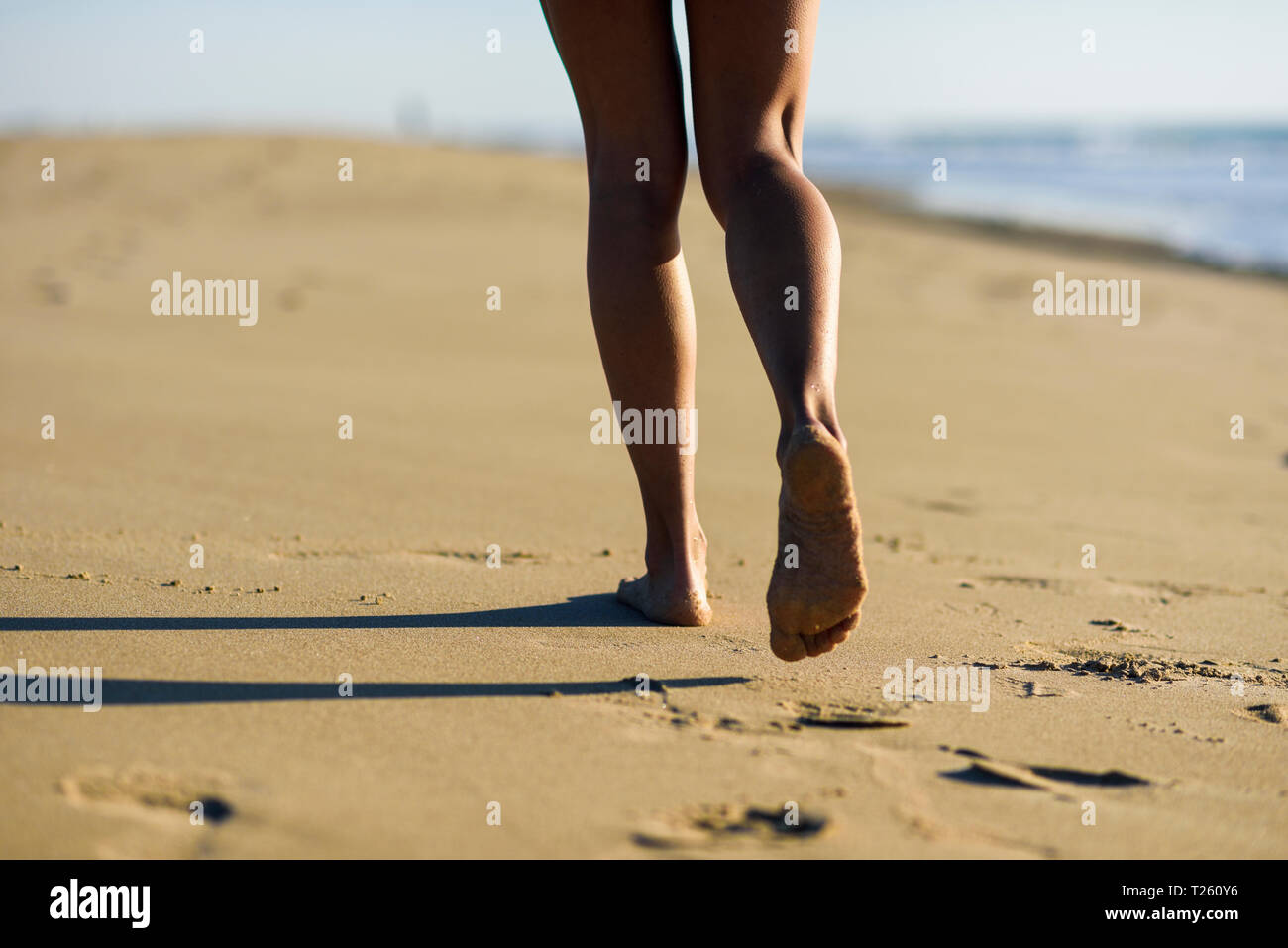 In der Nähe der Beine der Frau zu Fuß im Sand am Strand Stockfoto