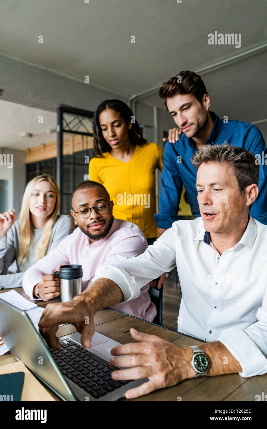 Business Team in einer Sitzung im Loft Büro auf Laptop zusammen Stockfoto