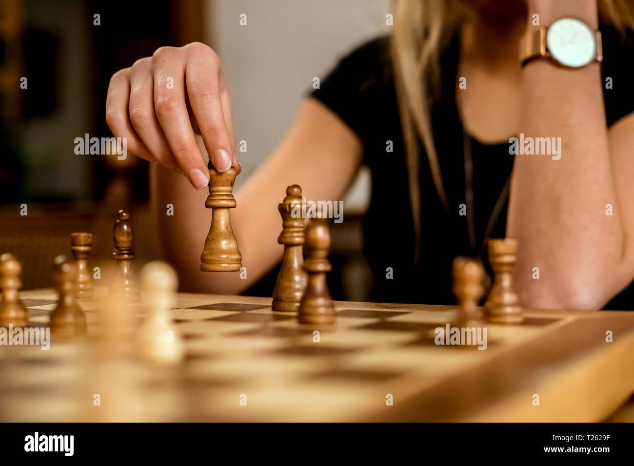 Nahaufnahme der Hand einer Frau, die eine Schachfigur Stockfoto