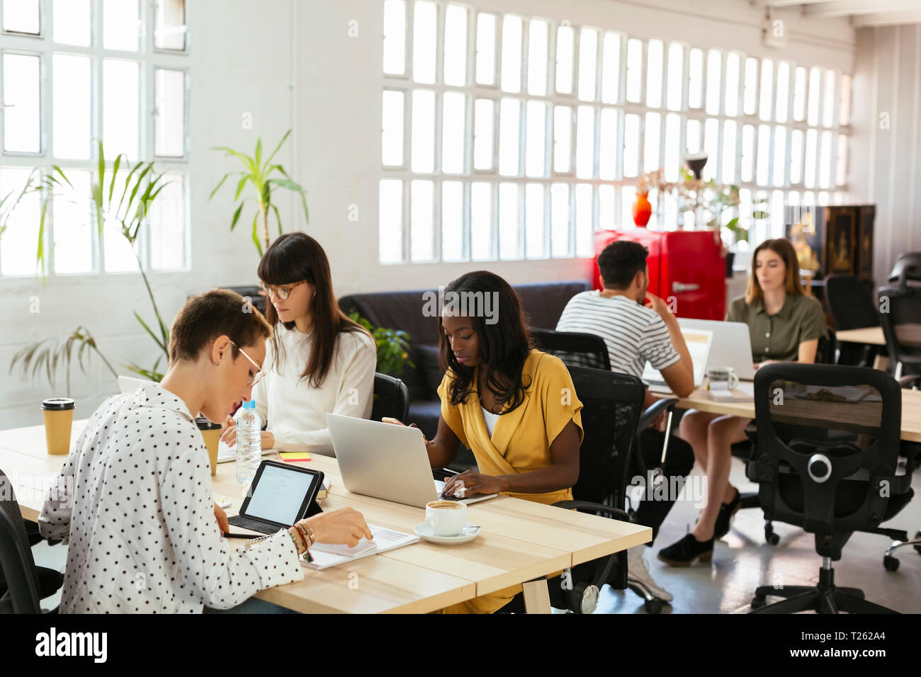 Kolleginnen und Kollegen arbeiten am Schreibtisch im Büro Stockfoto