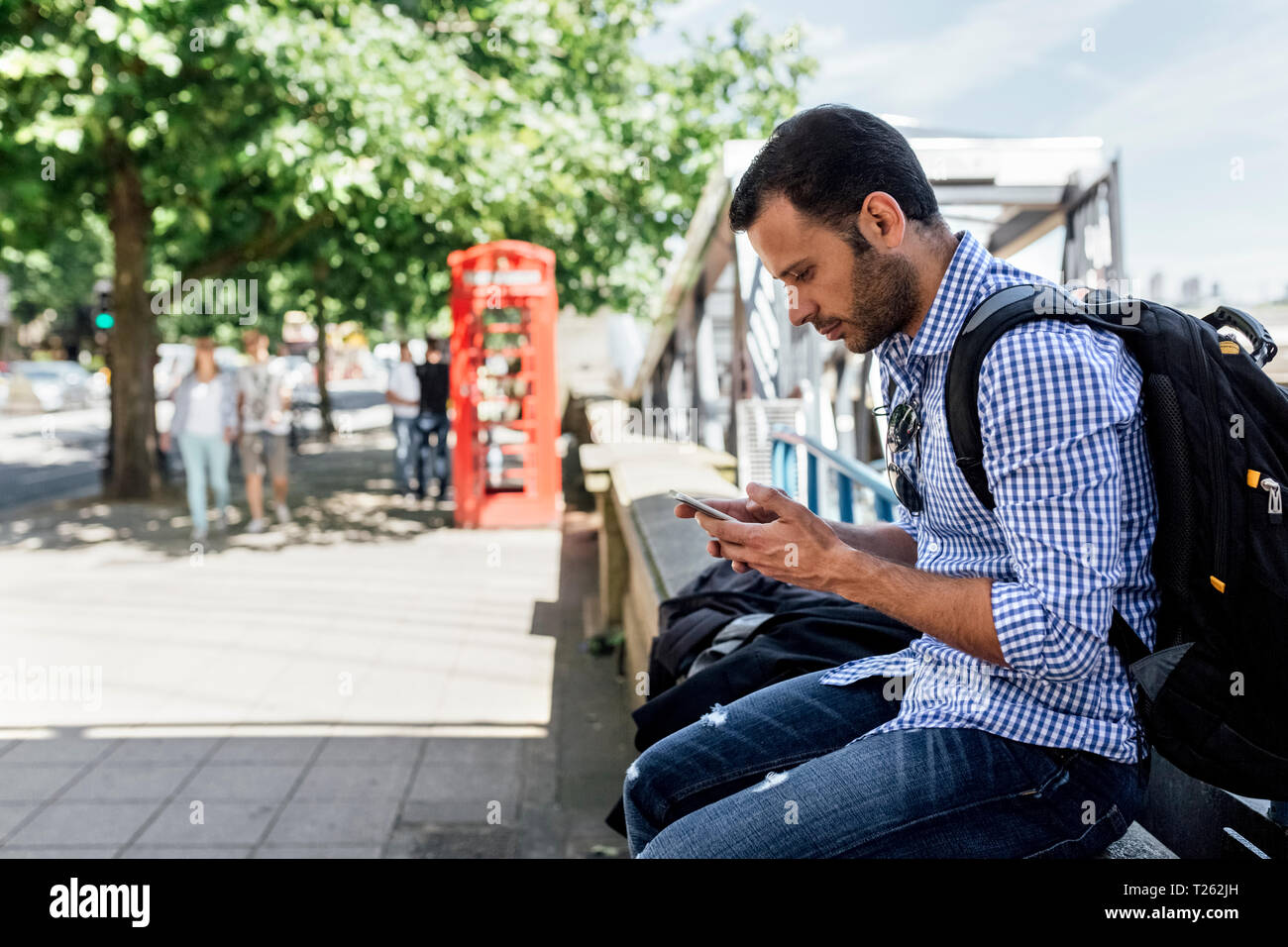 UK, London, Mann mit seinem Smartphone auf der Straße Stockfoto