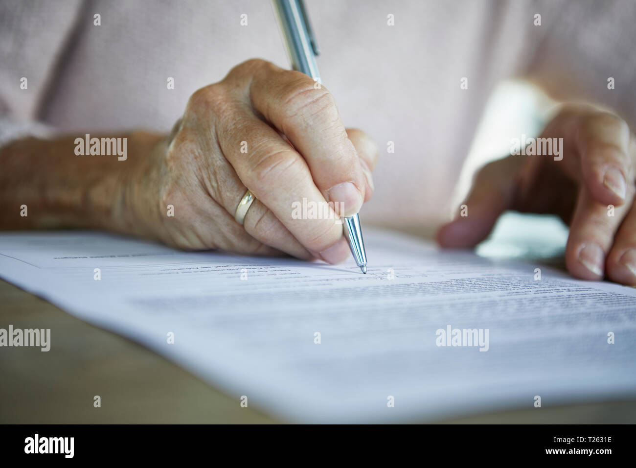 Die ältere Frau hand Signieren eines Dokuments, close-up Stockfoto