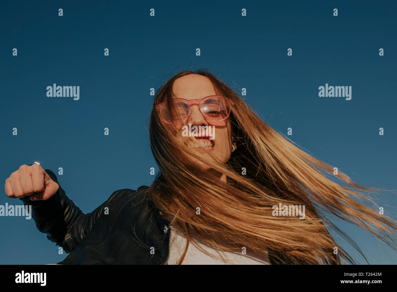 Portrait der aggressiven jungen Frau stanzen unter blauem Himmel Stockfoto