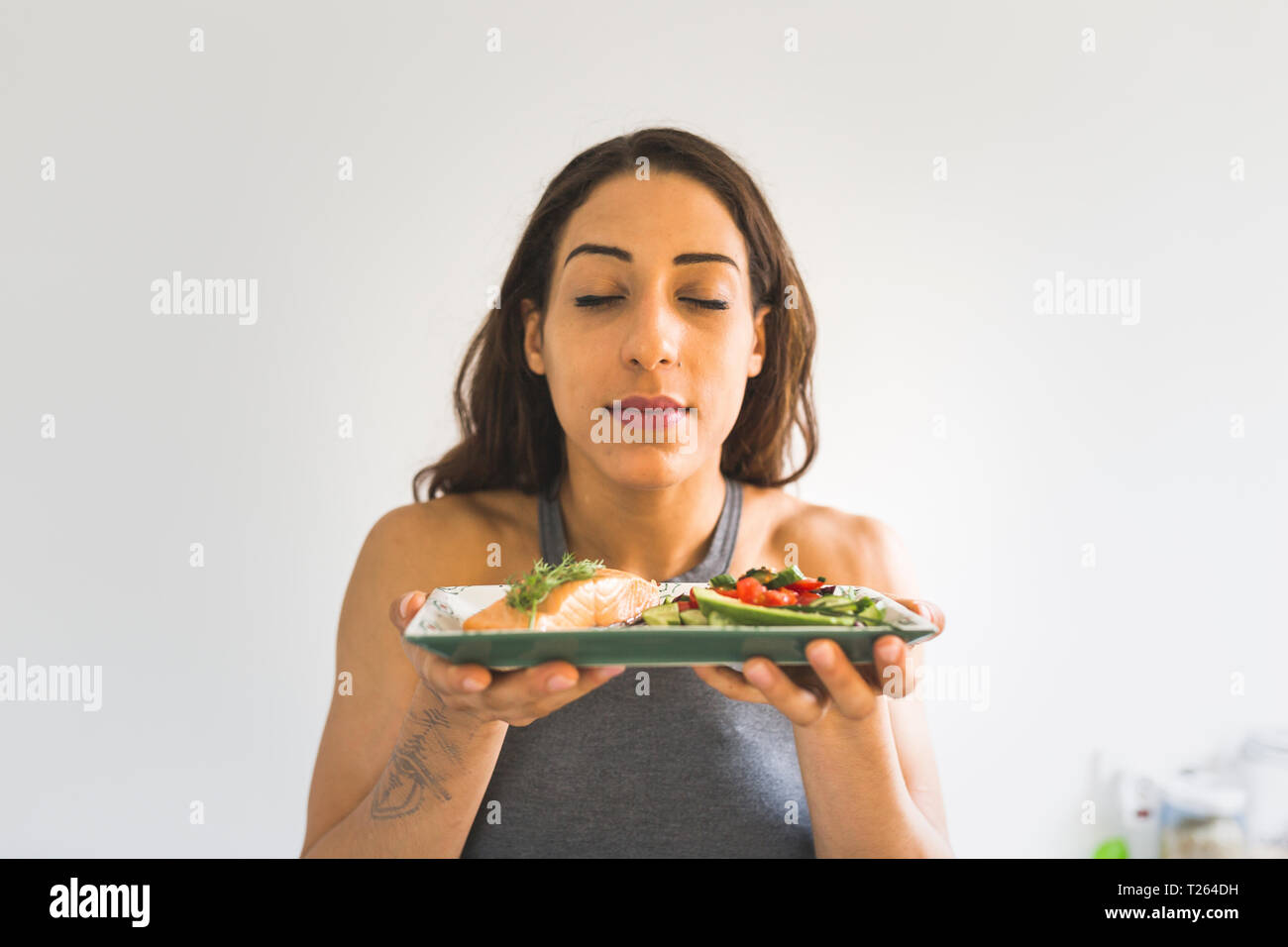 Frau hält Teller mit Gemüse und Lachs Stockfoto