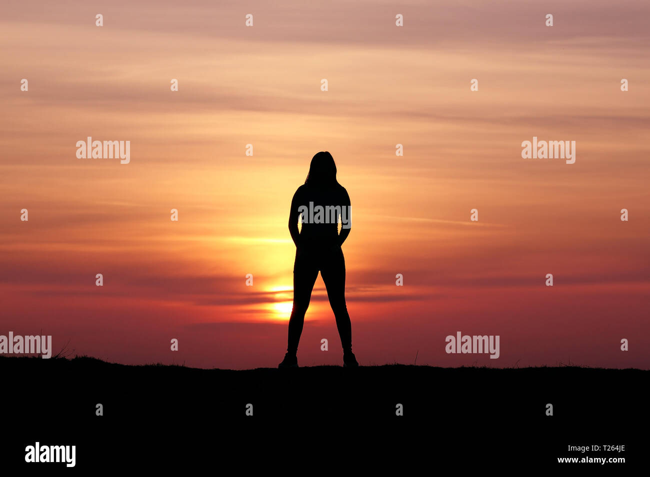 Silhouette eines Mädchens bei Sonnenuntergang, sportliche Mädchen, unglaubliche Sonnenuntergang Stockfoto