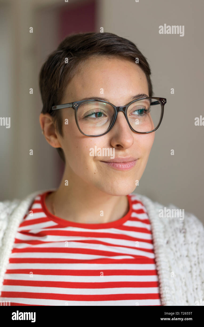 Porträt eines lächelnden jungen Frau mit kurzen Haaren, Brille Stockfoto