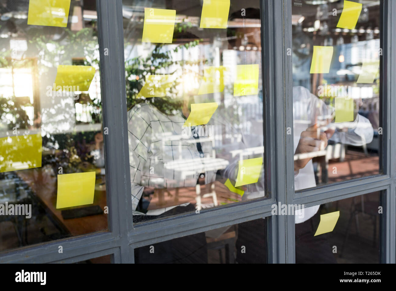 Geschäftsmann mit Kollege Brainstorming mit Post-its auf Fenster vorne Stockfoto