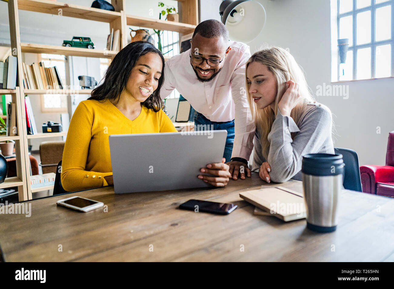 Zuversichtlich Business Team in einer Sitzung im Loft Büro auf Tablet-PC zusammen Stockfoto