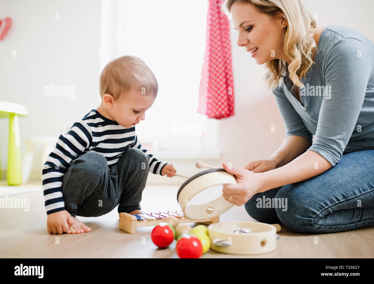 Mutter und Kleinkind Sohn spielen mit Musikinstrumenten zu Hause Stockfoto