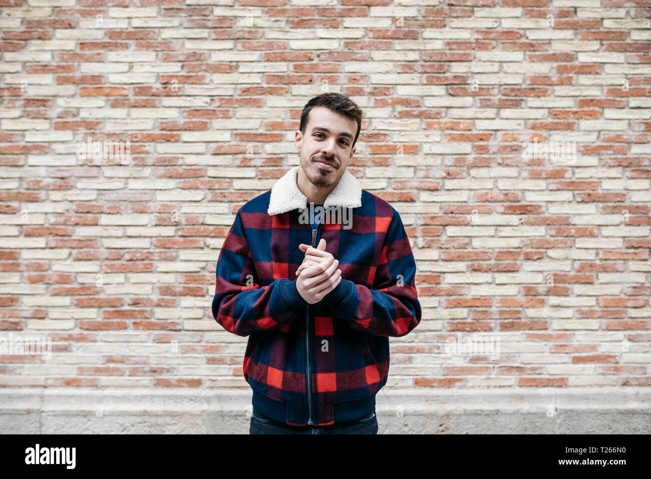 Junger Mann legere Kleidung die Hände reiben und Kamera Stockfoto