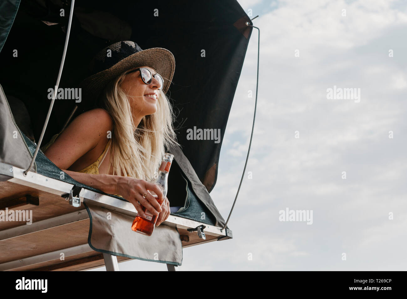 Lächelnde Frau in angehobener Zelt liegend Stockfoto