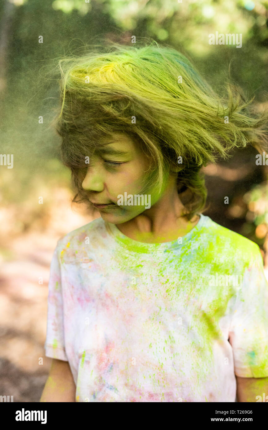 Junge schüttelt den Kopf, voller bunter Farbe pulverbeschichtet, Feiern, Holi, Festival der Farben Stockfoto