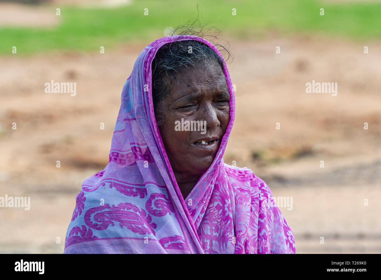 Eine ältere Dame in Indien, mit einem rosa Sari und fehlende Zähne Stockfoto