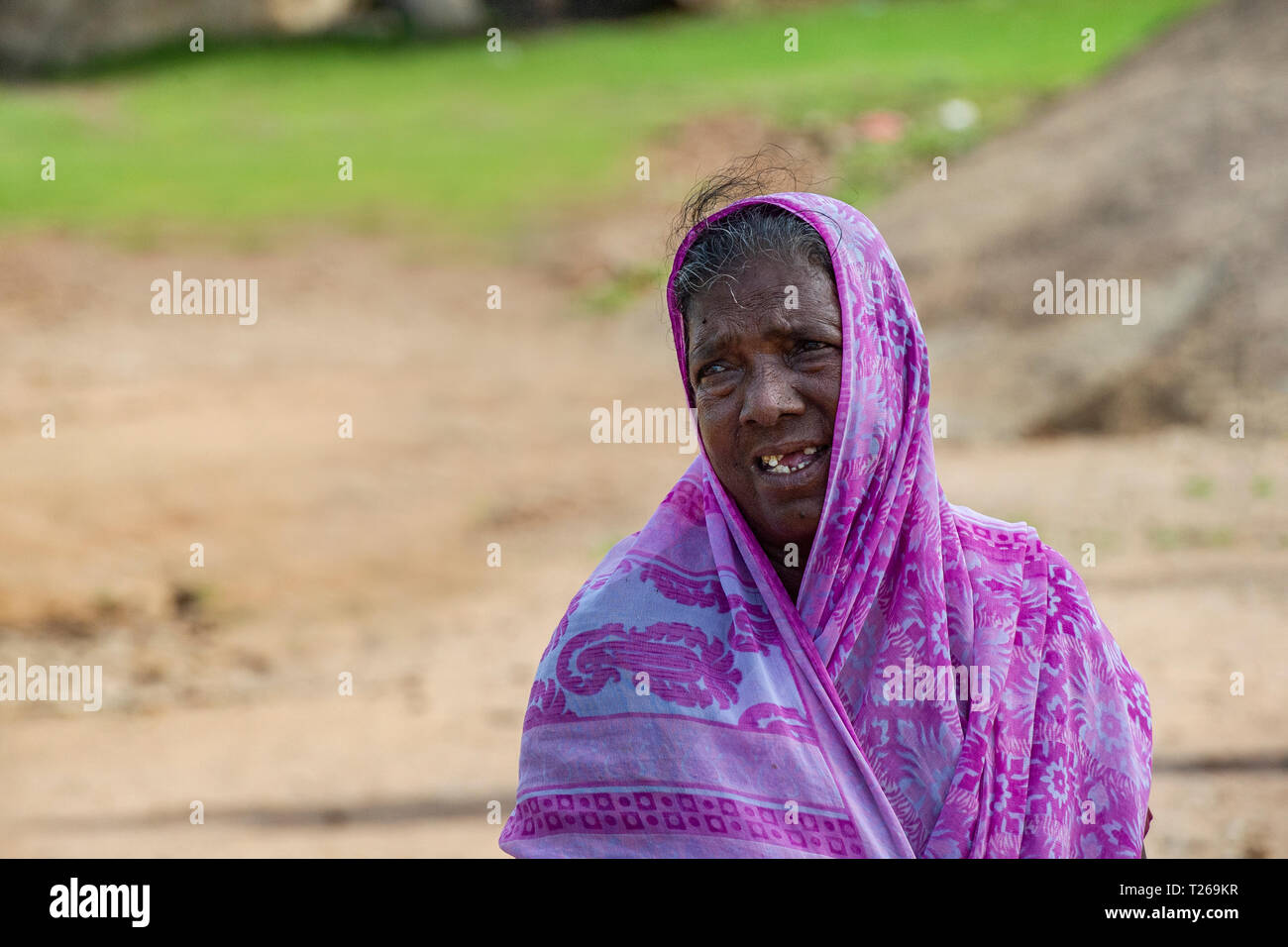 Eine ältere Dame in Indien, mit einem rosa Sari und fehlende Zähne Stockfoto
