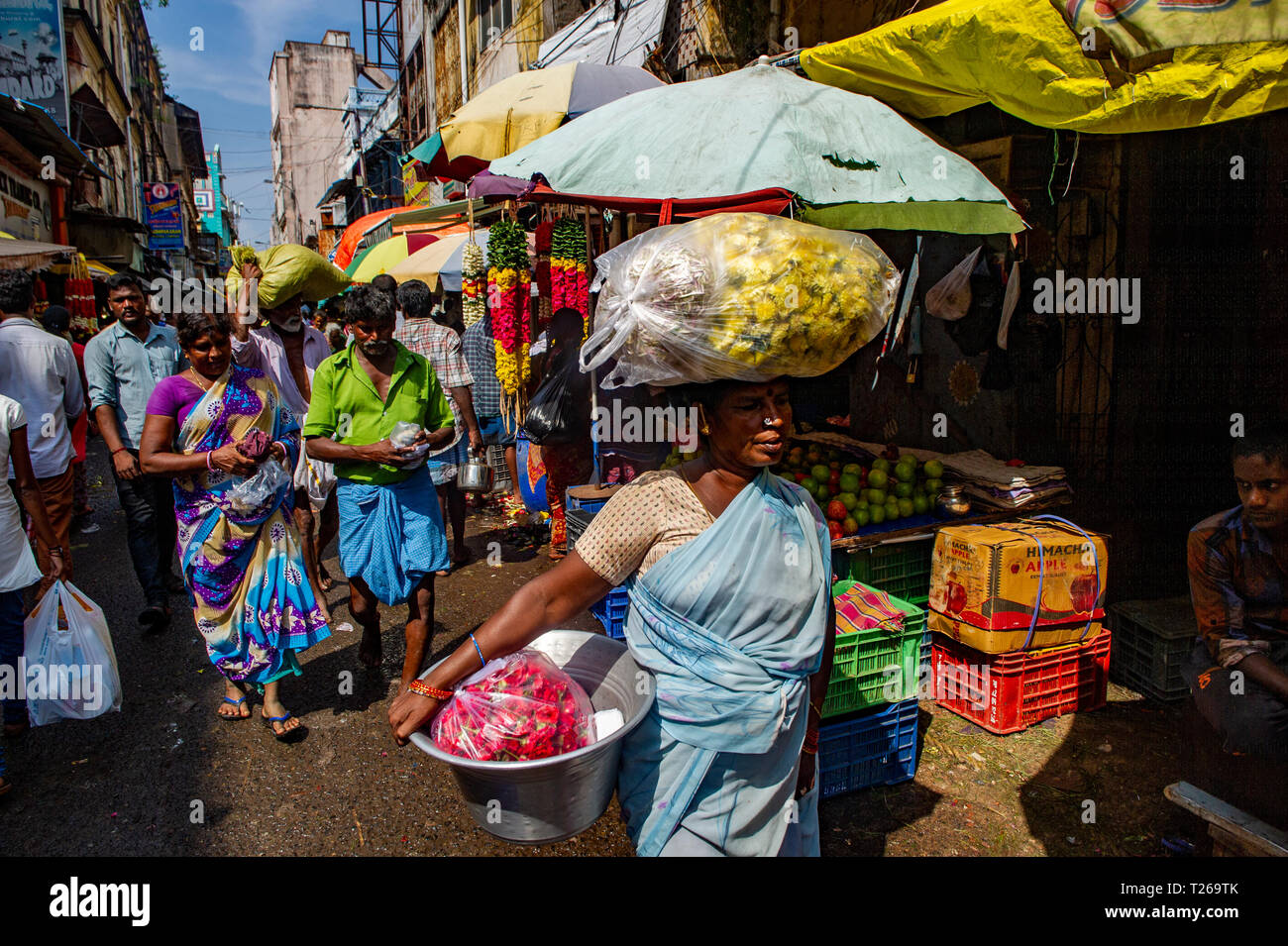 Der Händler trägt große Mengen von Lebensmitteln auf ihren Kopf in George Town Market, Chennai, Indien Stockfoto