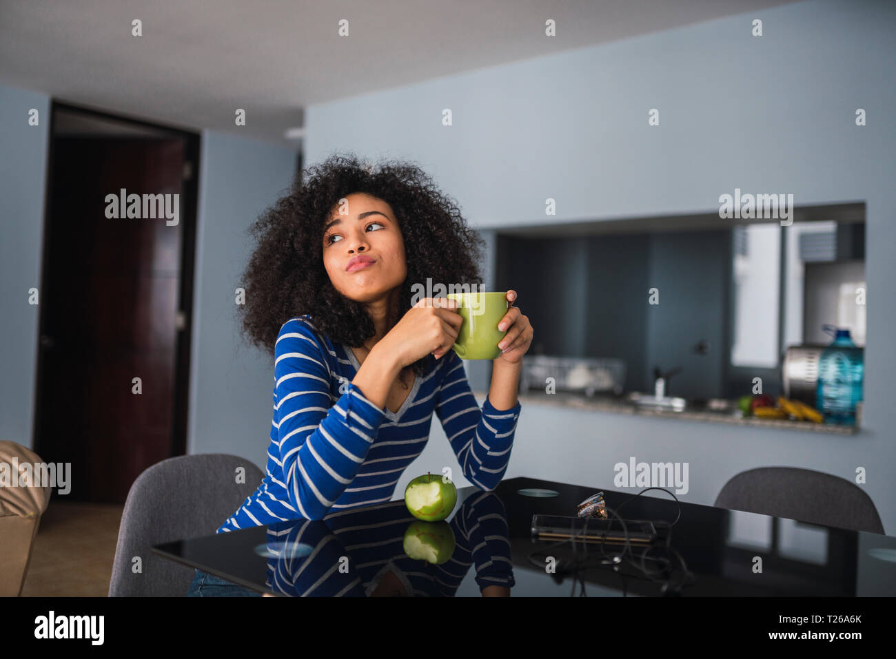 Porträt der jungen Frau trinkt Kaffee und Essen ein Apple zu Hause Stockfoto