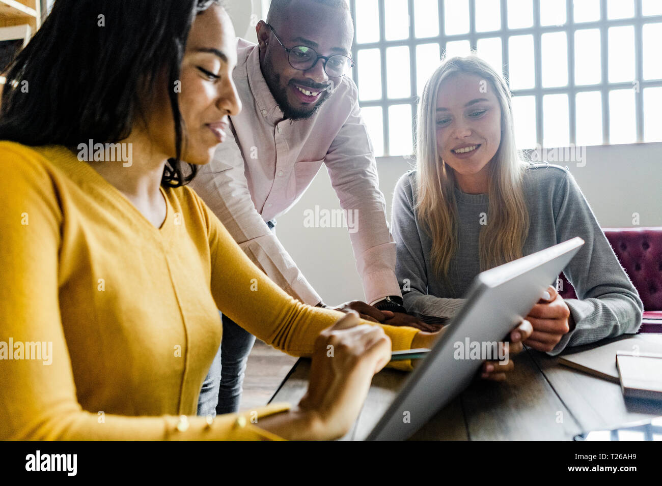 Zuversichtlich Business Team in einer Sitzung im Loft Büro auf Tablet-PC zusammen Stockfoto