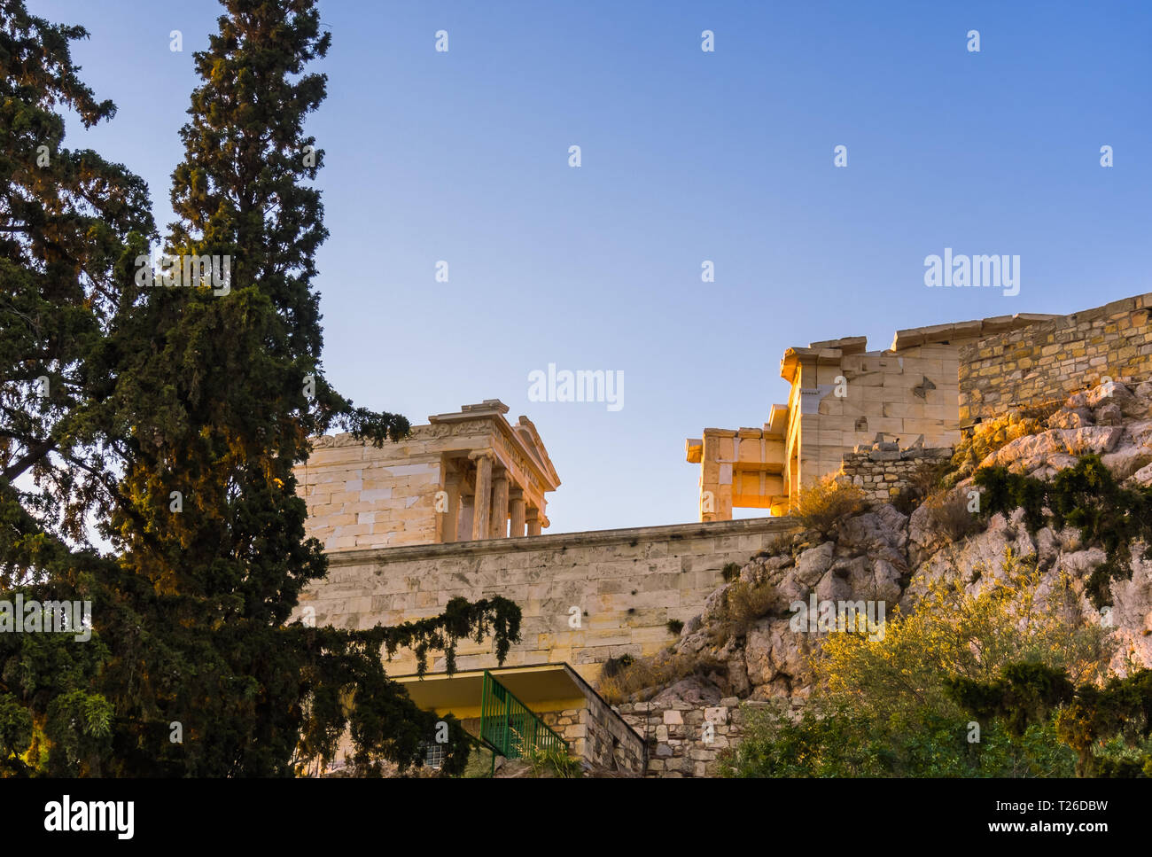 Ansicht von unten und seitlich von der Tempel der Athena Nike und Propyläen Eingangstor auf der Akropolis in Athen, Griechenland gegen den blauen Himmel Stockfoto