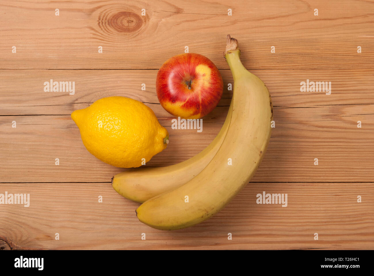 Zitrone, Apfel und Bananen auf einer hölzernen Hintergrund. Blick von oben. Stockfoto