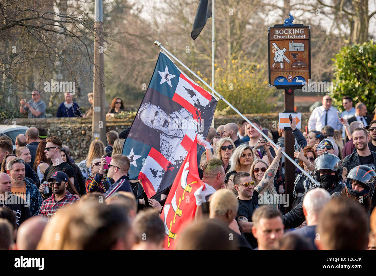 Essex, UK. Am 30. März 2019. Prodigy Fans mit einer Flagge mit einem Bild von Keith Flint bei der Beerdigung des verstorbenen Prodigy Sänger bei St Marys Kirche im Bocking, Essex heute. Credit: Phil Rees/Alamy leben Nachrichten Stockfoto