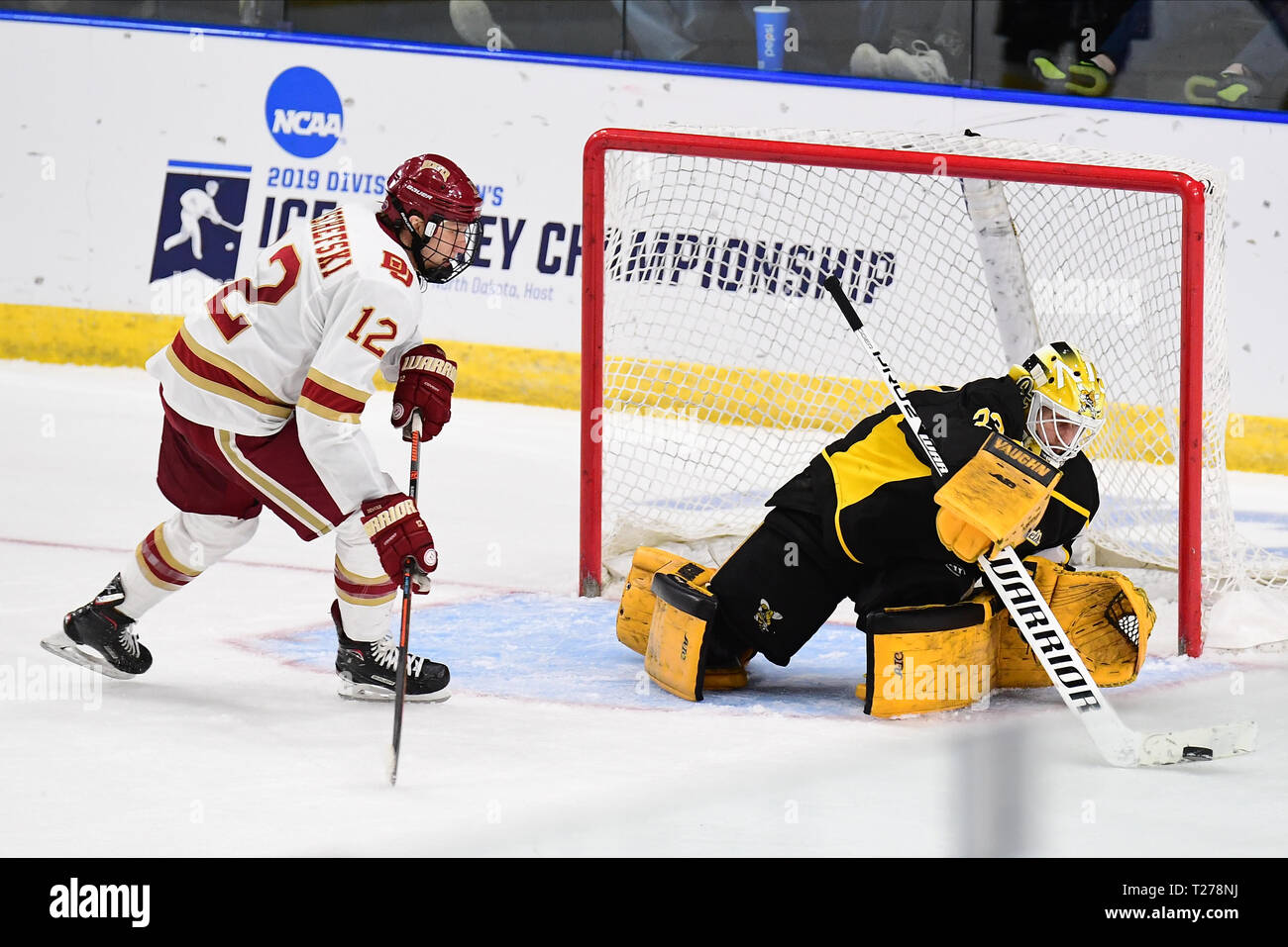 North Dakota, USA. Am 30. März 2019. American International gelben Jacken Torwart Zackarias Skog (33) Pokes entfernt einen Schuß am Denver Pioniere vorwärts Kohen Olischefski (12) Ansätze während der NCAA Men's Hockey West regionale Meisterschaft Spiel zwischen der Amerikanischen International College gelbe Jacken und die Denver Pioniere auf Scheels Arena, Fargo, ND. Denver besiegt AIC 3-0 auf dem gefrorenen vier zu bewegen. Foto von Russell Hons/CSM Credit: Cal Sport Media/Alamy leben Nachrichten Stockfoto