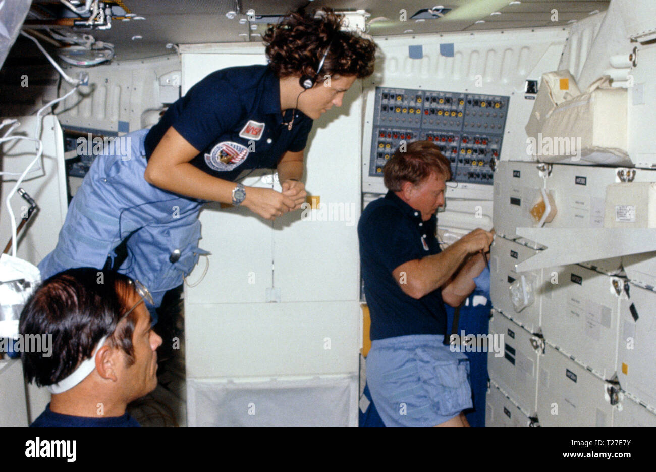 41 G -102-003 (5-13 Okt 1984) - - - - Astronaut Kathryn D. Sullivan, 41-G-Mission Specialist, schwimmt in einem middeck Szene ein Mehr stationäre Paar Crewmitglieder - - - Astronauten Robert L. Crippen, crew Commander zu verbinden; und Jon A. McBride, Pilot. Der vorstehende Artikel in der Nähe der Stauraum ist ein Krimsky Regel, Teil der in der Nähe von sehschärfe Experiment, in dem die Jüngsten NASA Space Travelers teilgenommen haben. Stockfoto