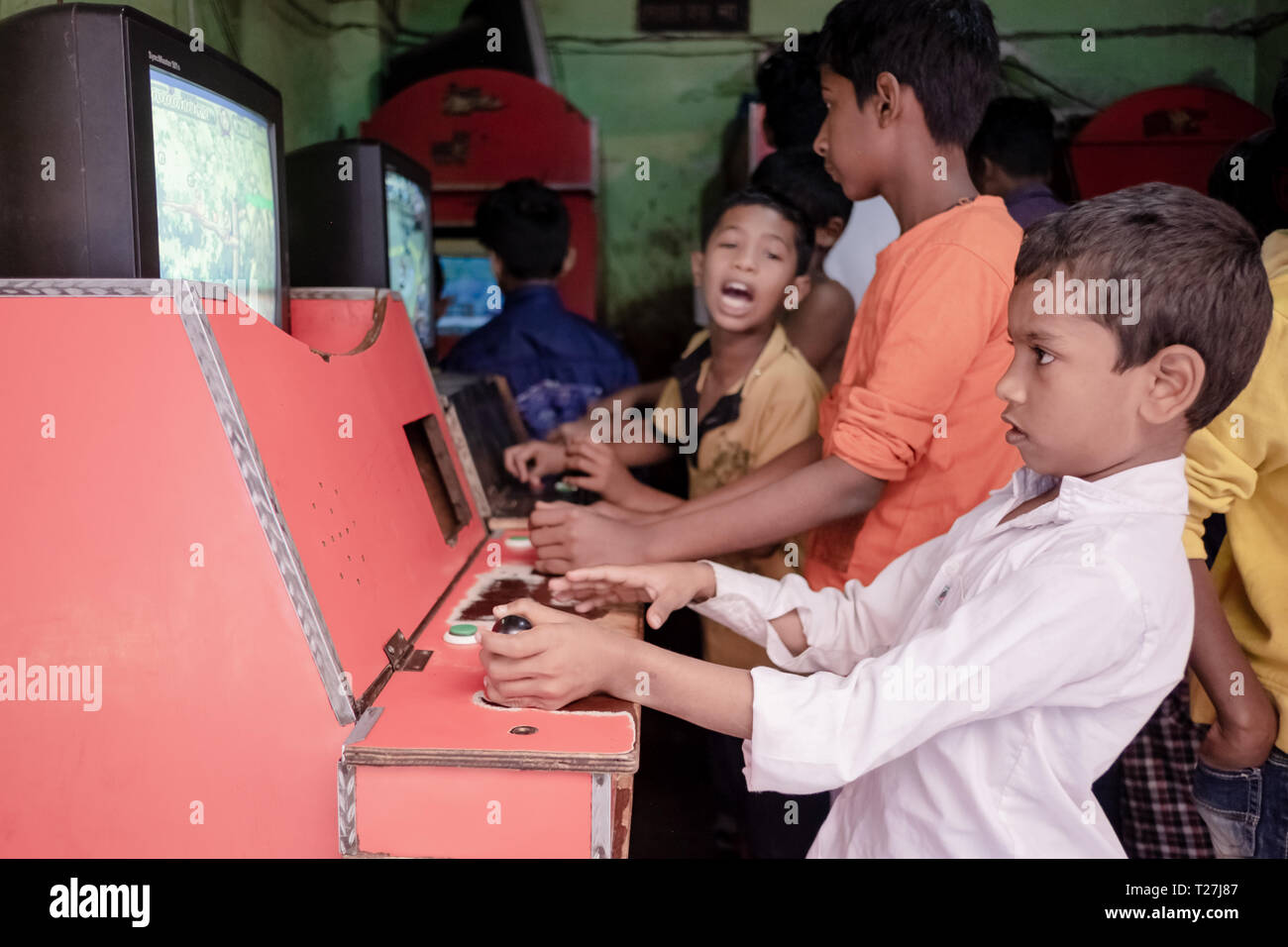 Jungen spielen Old Style Arcade Spiele in Genf Camp, gestrandete Pakistaner Enklave in Dhaka, Bangladesh. Stockfoto