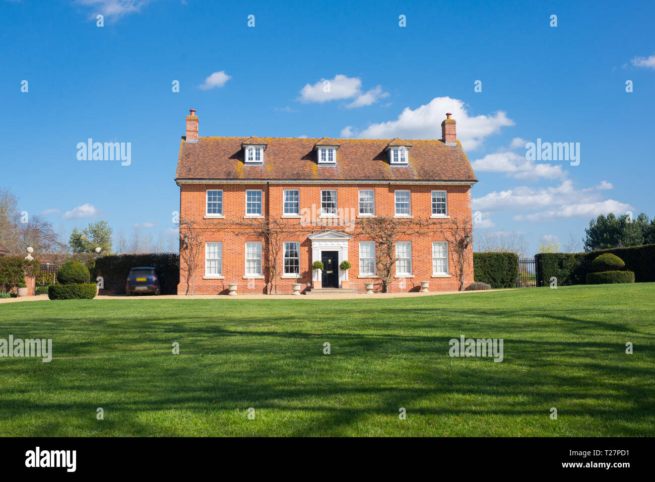 Elegante englische Country Manor Herrenhaus Grad 2 Viktorianischen zeit Immobilien in rotem Backstein aufgeführt. Vorderansicht mit großem Garten und Rasen Stockfoto