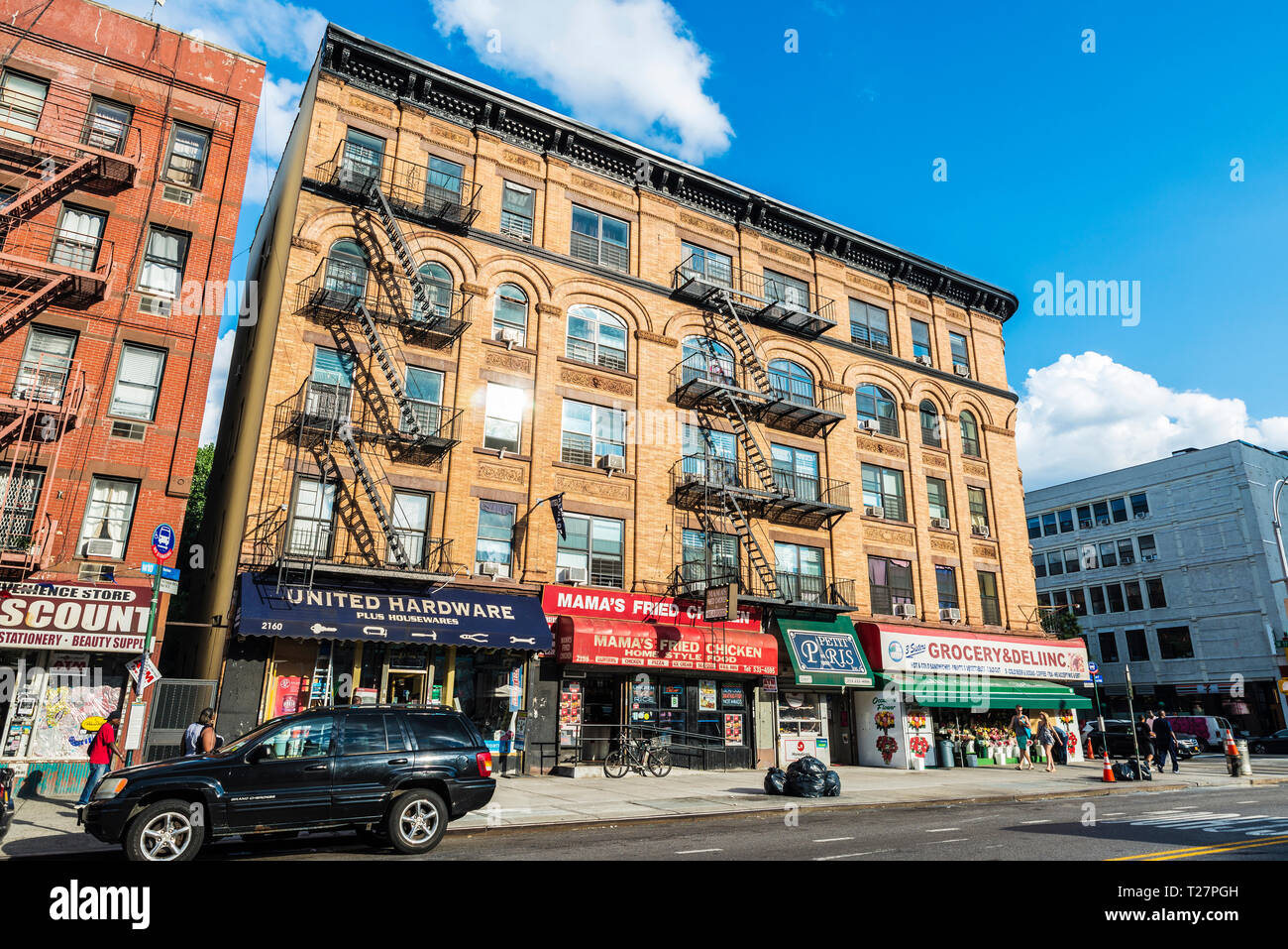 New York City, USA - 29. Juli 2018: Lebensmittelgeschäft, Restaurant und andere Geschäfte mit Menschen um in Harlem, Manhattan, New York City, USA Stockfoto