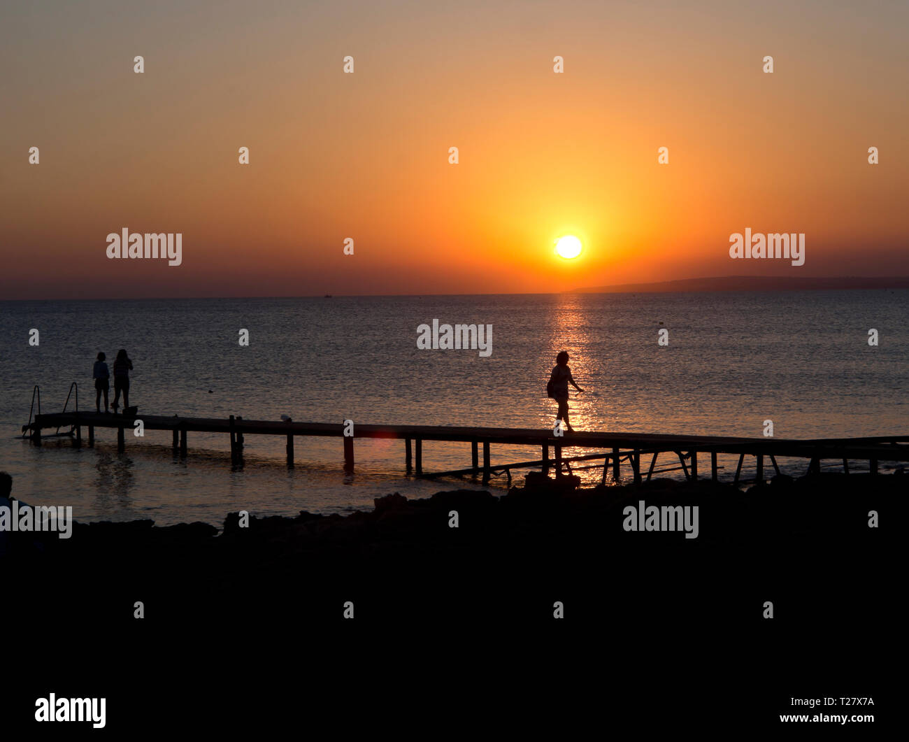 Sonnenuntergang in Ayia Napa Zypern, einem bunten sunn Einstellung im Mittelmeer mit Silhouettiert Touristen Stockfoto