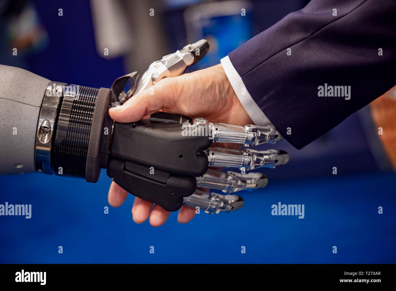 Hand eines Geschäftsmannes Händeschütteln mit einem Android Roboter. Das Konzept der menschlichen Interaktion mit der künstlichen Intelligenz. Stockfoto