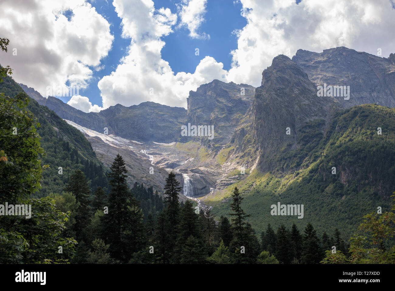 Panoramablick auf Berge Szene und weit entfernten Wasserfall im Nationalpark von Dombay, Kaukasus, Russland. Sommer Landschaft, Sonnenschein Wetter und sonnigen Tag Stockfoto
