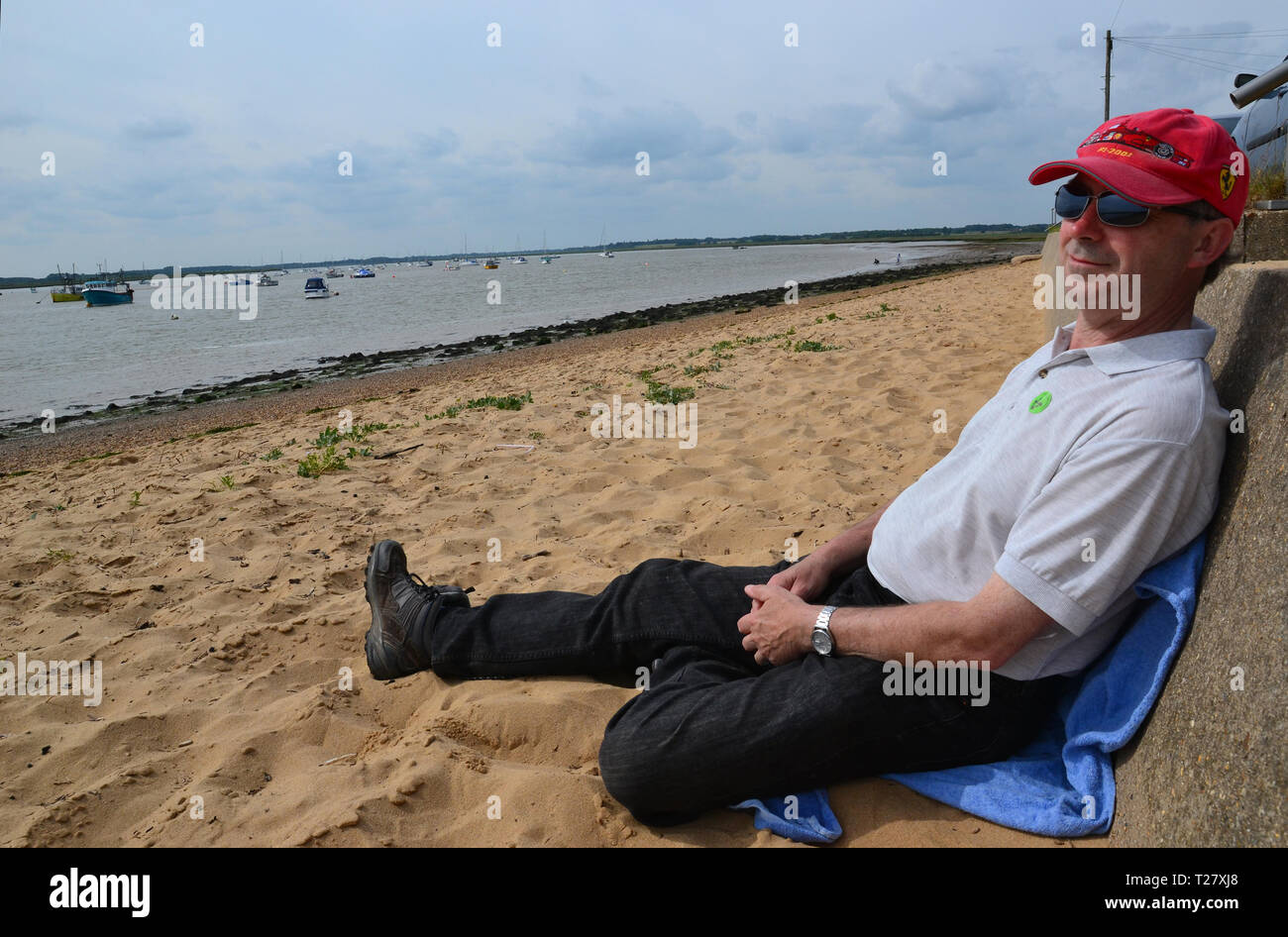 Mann am Strand entspannen bei Bawdsey, Suffolk, England, Großbritannien Stockfoto