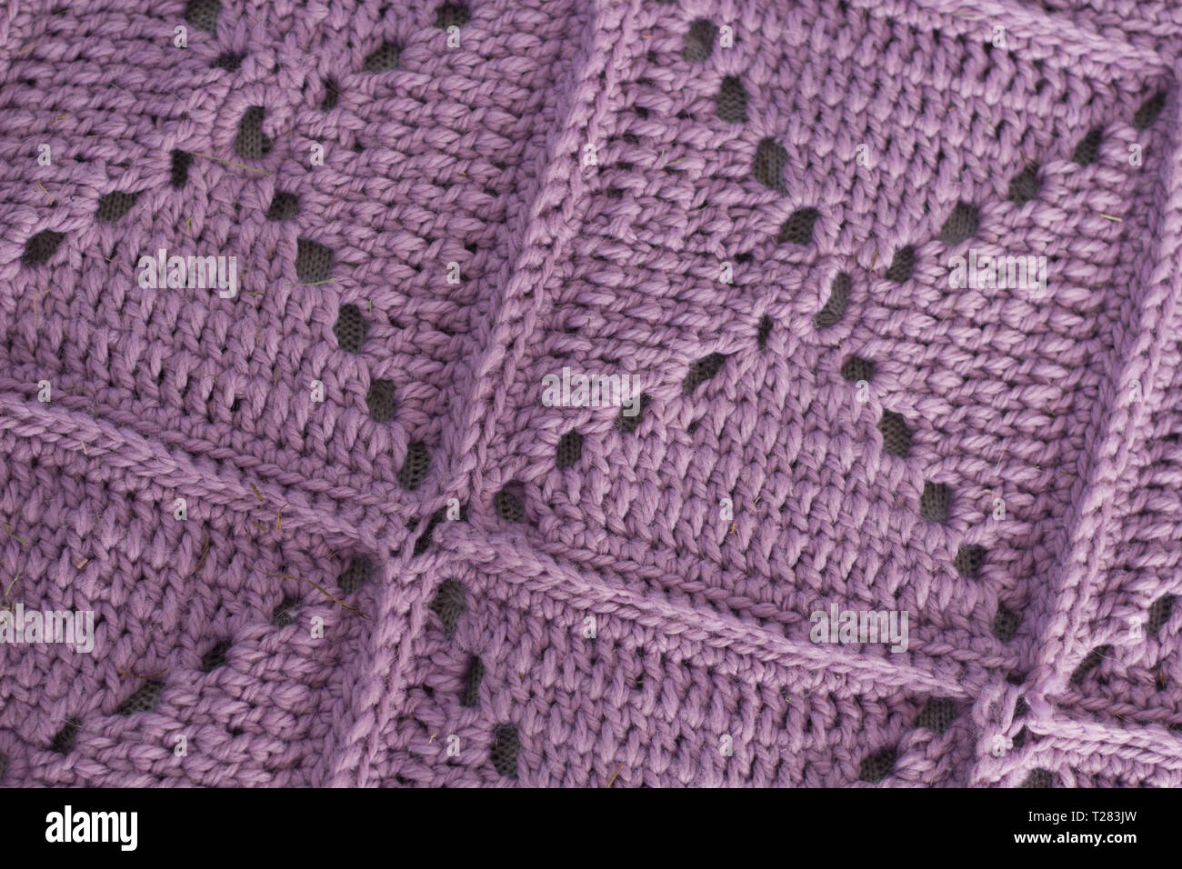 Textur gestrickte Decke. Gehäkelte Überdecke. Lila Tagesdecke Stockfoto