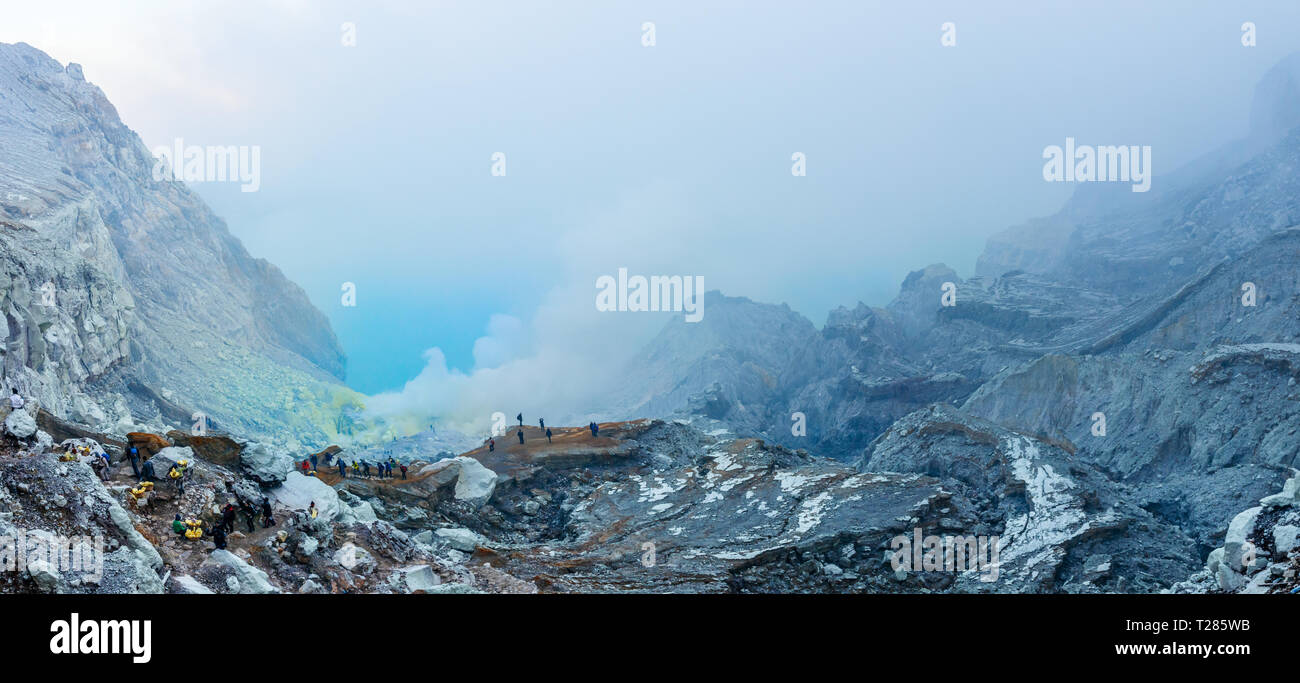 Blick auf den Kawah Ijen Kratersee vulkanischen See mit Touristen und Schwefel Schwefelsäure Bergleute und giftige Gase, die sich aus der Unterseite. Java, Indonesien. Stockfoto