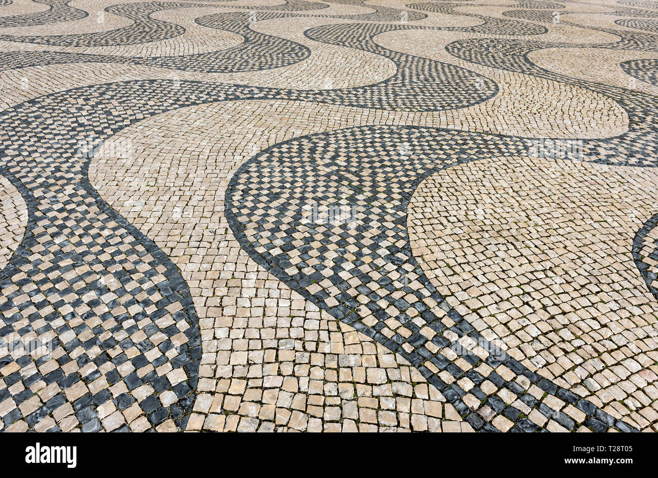 Die wellenförmige Kopfsteinpflaster der Plaza, neben dem Denkmal der Entdeckungen in Belem, Lissabon, Portugal Stockfoto